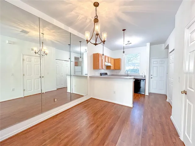 a kitchen with stainless steel appliances kitchen island a hardwood floor and a sink