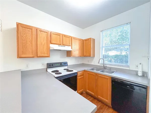 a kitchen with a sink stove top oven and cabinets