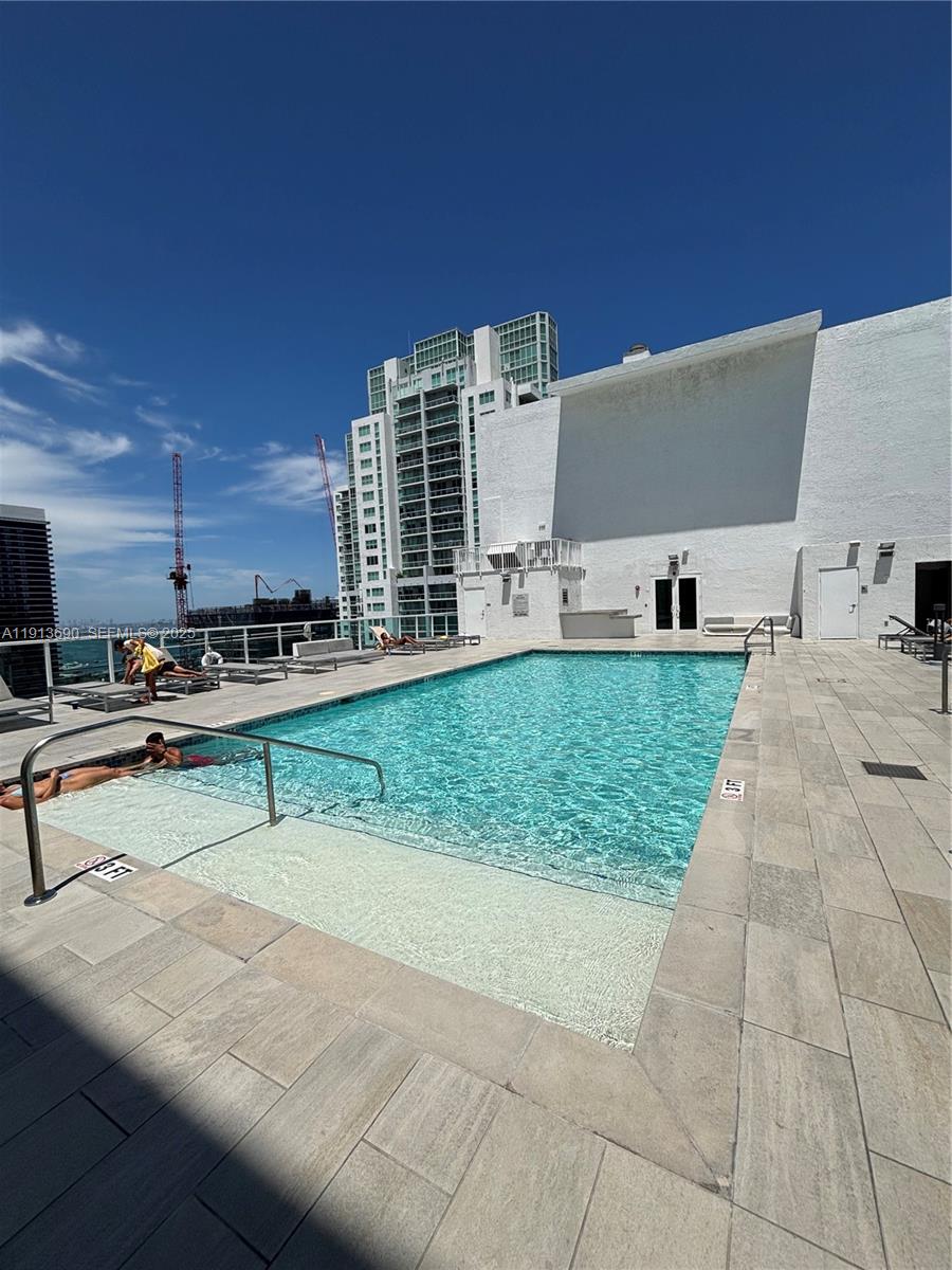 133 Northeast 2nd Avenue, Unit 1519 Miami, FL 33132 - Photo 23 of 41 a view of a swimming pool with a chair and tables