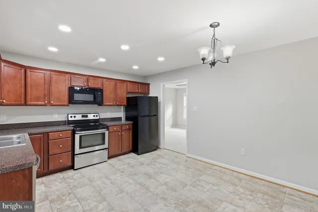 a kitchen with stainless steel appliances granite countertop a refrigerator a stove top oven a sink and dishwasher