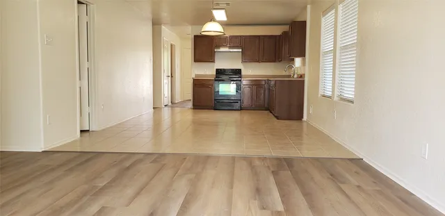 a view of a kitchen with wooden floor and electronic appliances