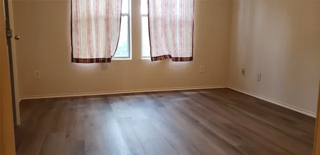 a view of a room with wooden floor and a window