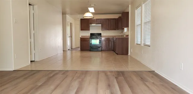 a view of a kitchen with wooden cabinet and a refrigerator