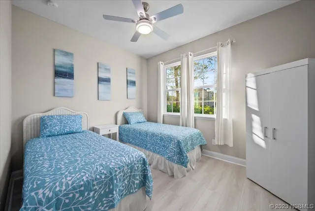 a bedroom with two beds and a large window