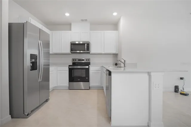 a kitchen with stainless steel appliances a refrigerator sink and microwave