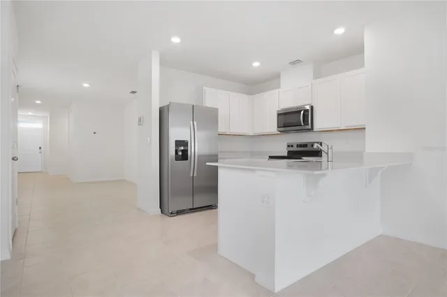 a kitchen with stainless steel appliances a refrigerator and a stove top oven