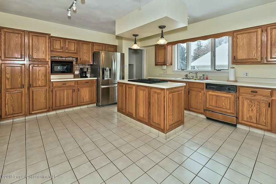 361 Upper Demunds Road Dallas, PA 18612 - Photo 6 of 27 a large kitchen with stainless steel appliances wooden cabinets a stove a sink and a window