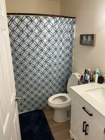 a white toilet sitting next to a white wall