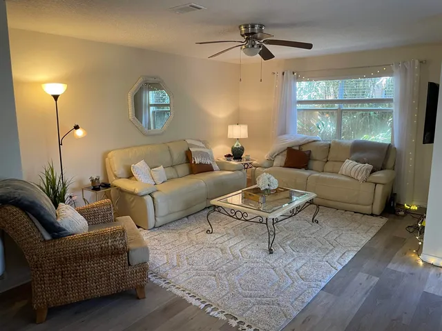 a living room with furniture a large window and a rug
