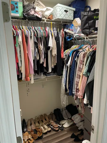 a view of walk in closet with clothes and shoes