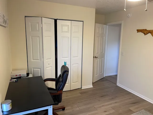 a view of a workspace with furniture and a window