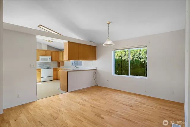 a kitchen with granite countertop a stove a sink and a refrigerator