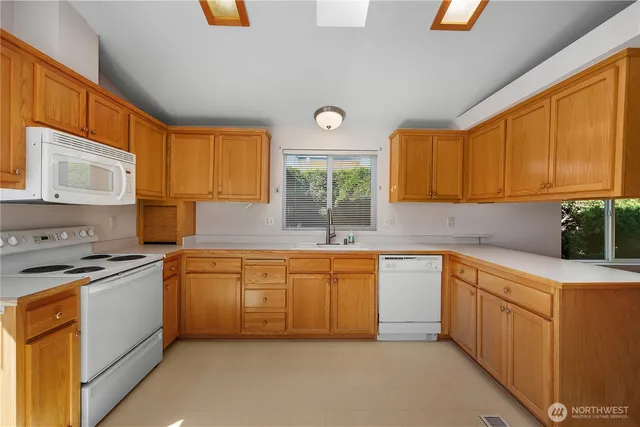 a kitchen with stainless steel appliances granite countertop a stove a sink and a microwave
