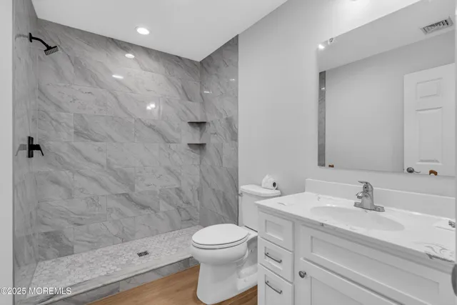 a bathroom with a sink a toilet and shower