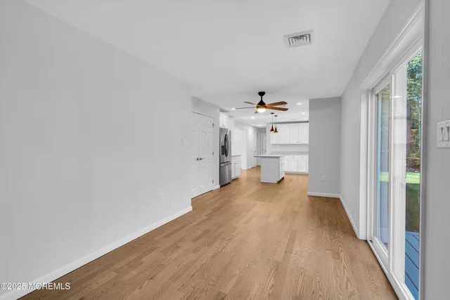 a view of a hallway with wooden floor and a window