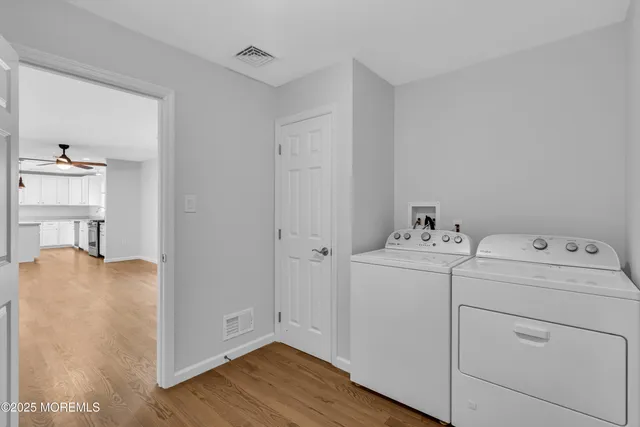 a view of washer and dryer with bathroom in the background
