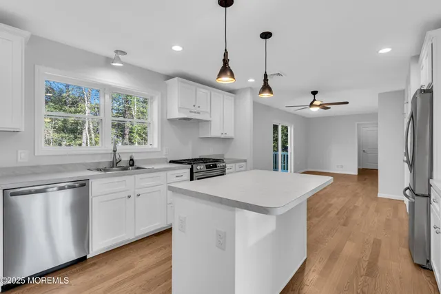a kitchen that has a lot of cabinets and a wooden floor