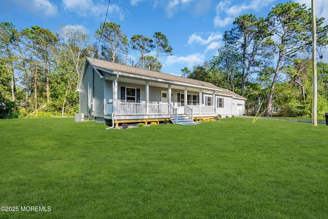 a front view of a house with a garden and lake view