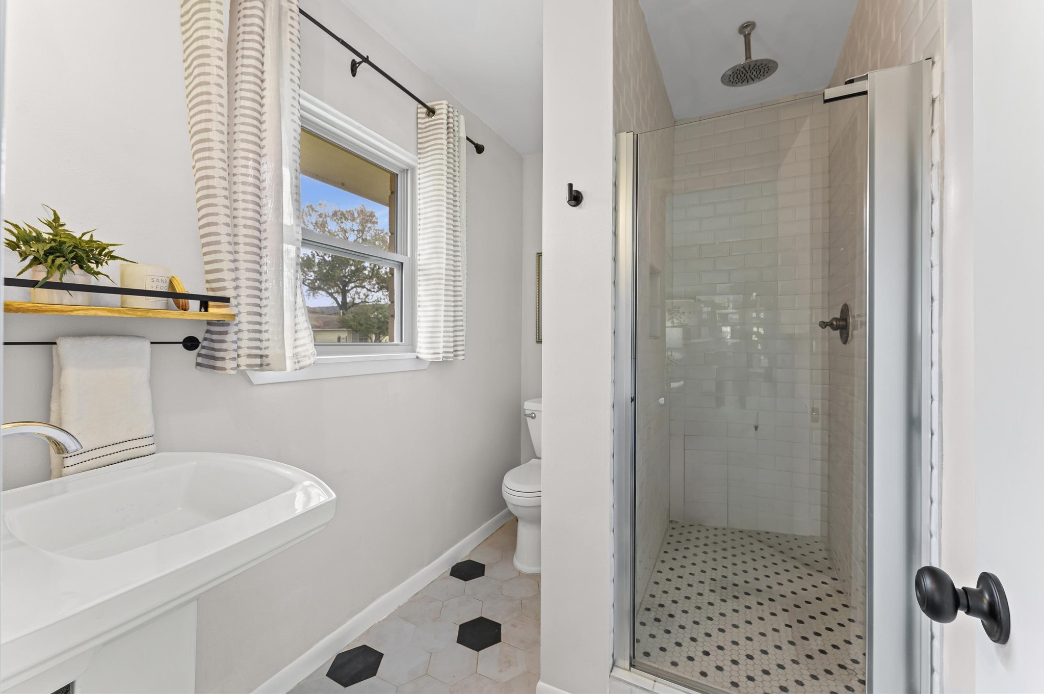 1219 Candlelight Lane Houston, TX 77018 - Photo 17 of 36 The primary ensuite was completely gutted during the 2020 renovation, resulting in a fresh, spa-like retreat. Clean finishes, continuation of the vintage-style tile flooring and a walk-in shower create a calm space to start and end the day.