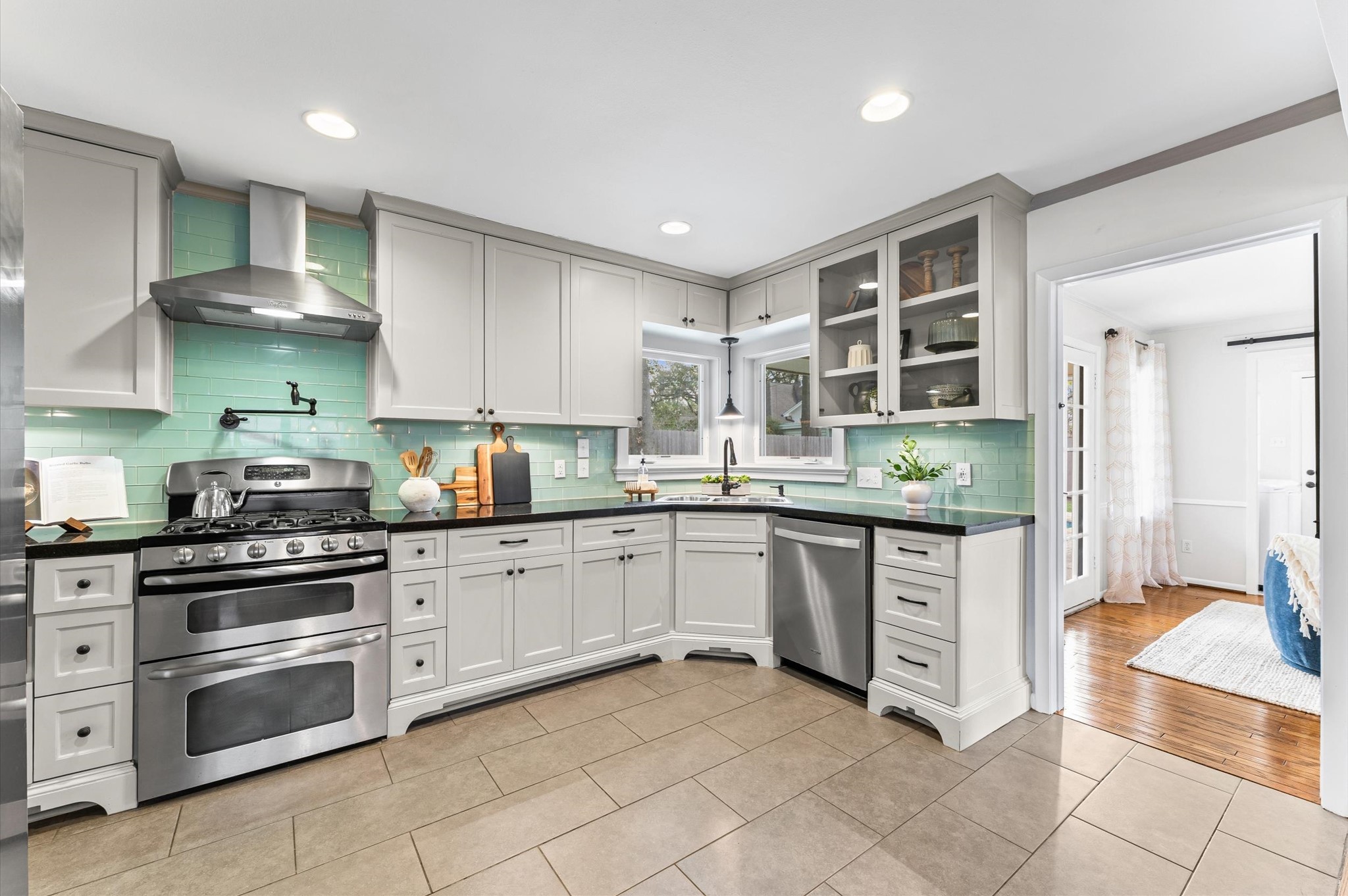 1219 Candlelight Lane Houston, TX 77018 - Photo 2 of 36 Kitchen was designed with real life in mind, featuring granite counters, under-cabinet lighting, and a glass subway tile backsplash. A pot filler, pull-out spice drawer, and built-in microwave make cooking feel effortless.