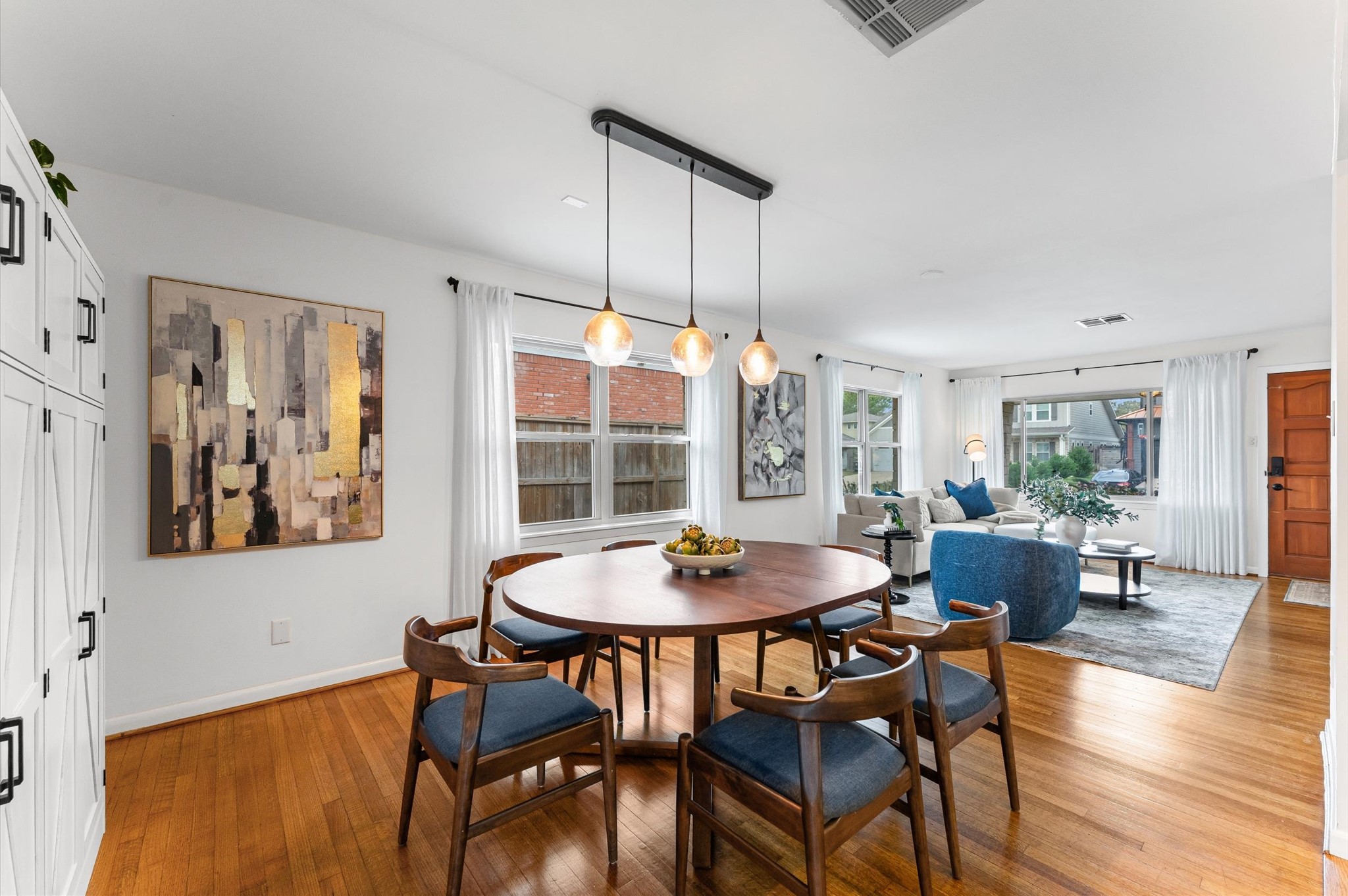 1219 Candlelight Lane Houston, TX 77018 - Photo 10 of 36 The seamless transition from dining to living highlights the home’s thoughtful design and refreshed hardwood floors. It’s a layout that adapts easily to everyday living or gatherings with friends.