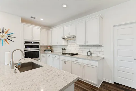 a kitchen with a sink stove and cabinets