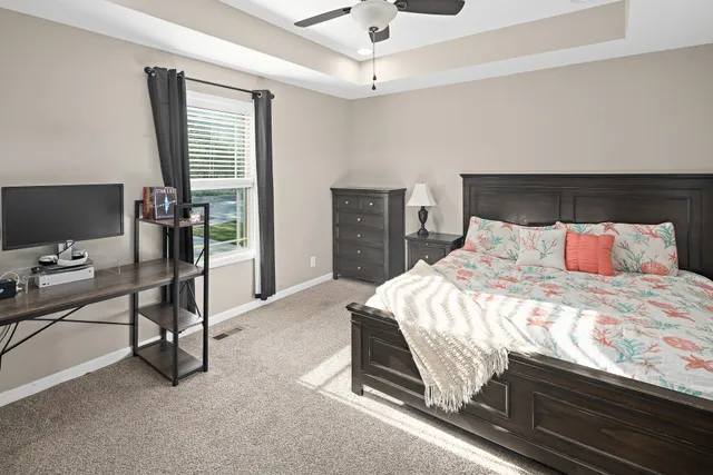 a bedroom with a bed and a flat tv screen on the dresser