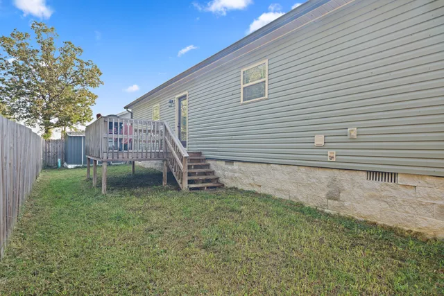 a view of a house with a yard and deck