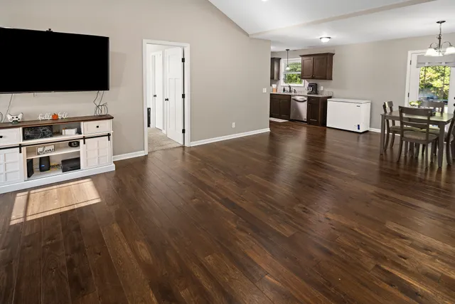 a living room with stainless steel appliances furniture and a flat screen tv