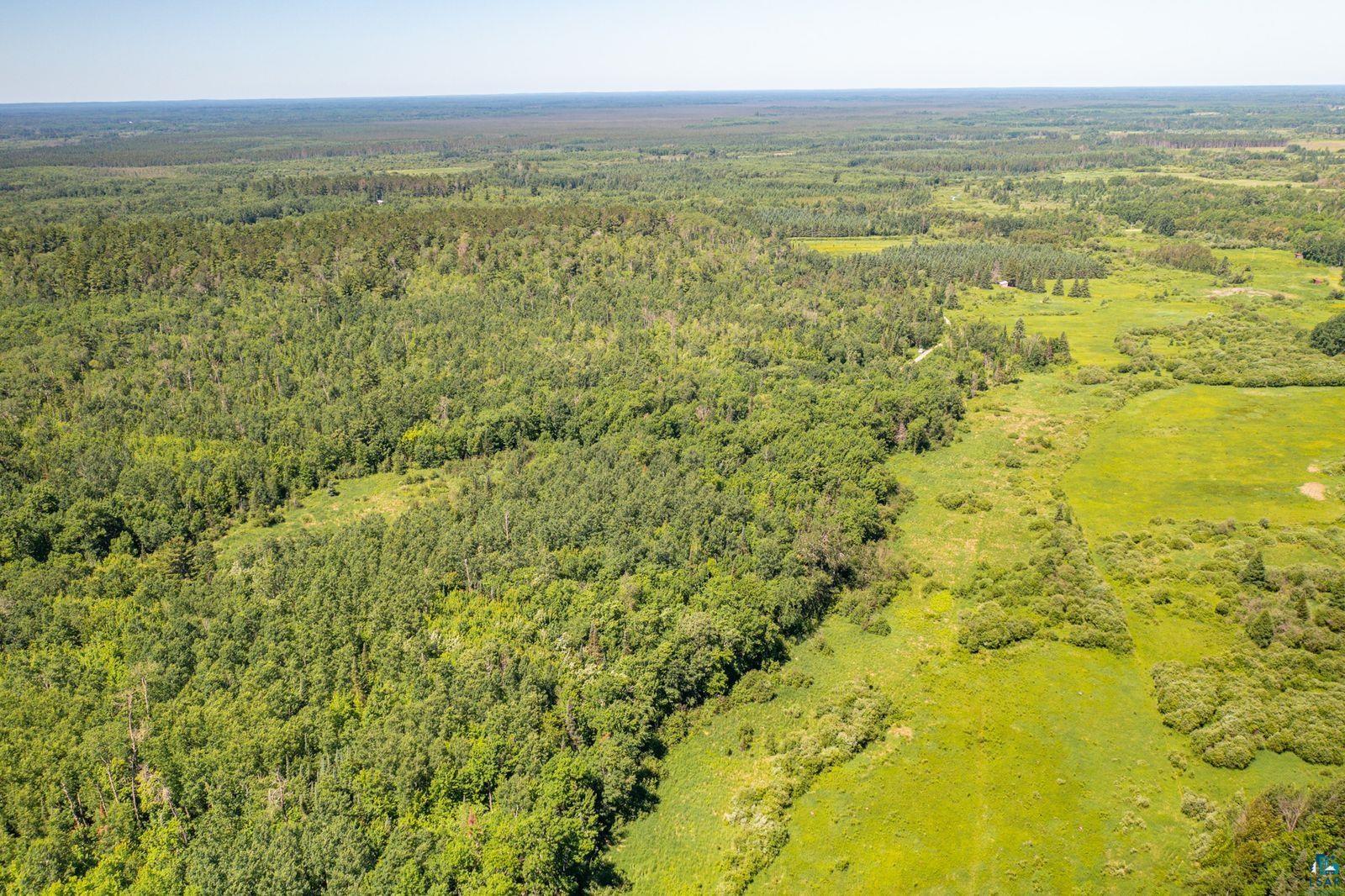 9734 Alango Road Angora, MN 55703 - Photo 36 of 41 Expansive aerial landscape featuring a substantial tree line, varied foliage, open grassy areas, and a clear horizon