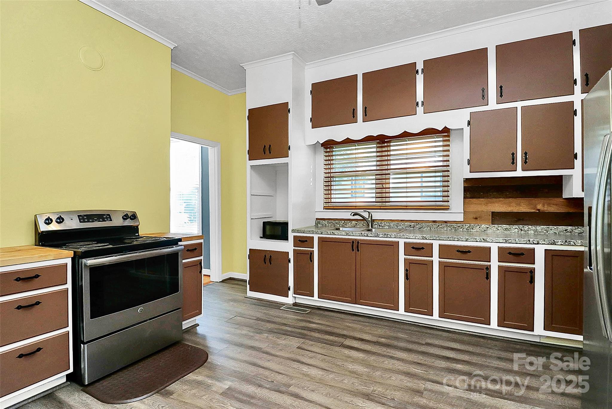 511 West Elliott Street Chester, SC 29706 - Photo 17 of 32 a view of a kitchen with stainless steel appliances wooden floor and a window