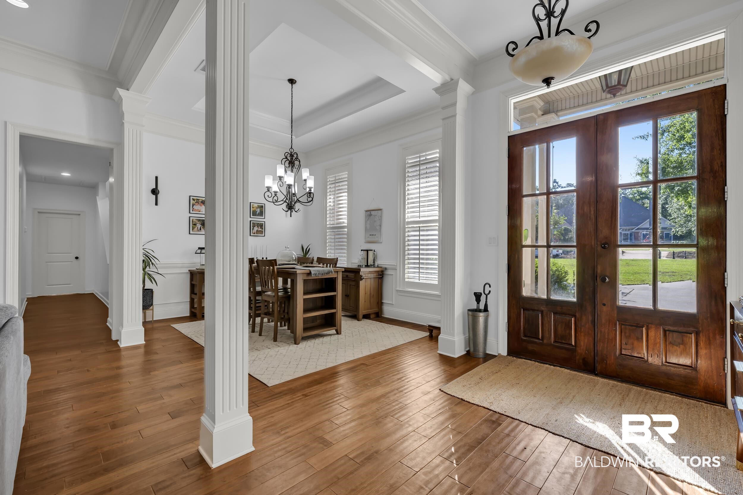 8137 Pine Run Daphne, AL 36527 - Photo 8 of 67 Foyer featuring double entry doors with transom window, wood-finish flooring, decorative columns, and a coffered ceiling in the adjacent dining area