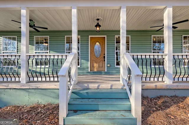 an empty room with wooden floor fireplace and windows