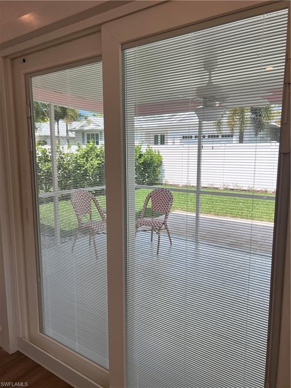 1793 Smugglers Cove, Unit B Naples, FL 34112 - Photo 11 of 23 a porch with a bench and floor to ceiling window