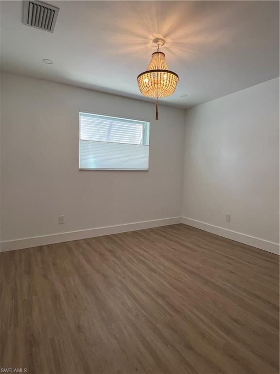 1793 Smugglers Cove, Unit B Naples, FL 34112 - Photo 12 of 23 a view of an empty room with a window and wooden floor