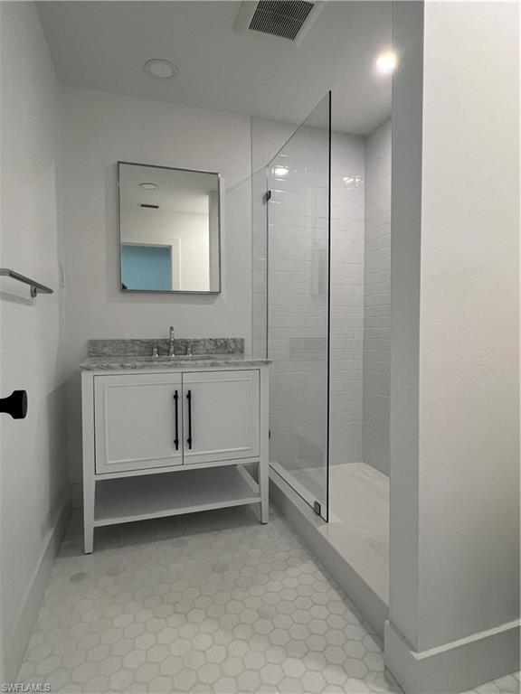 1793 Smugglers Cove, Unit B Naples, FL 34112 - Photo 13 of 23 a bathroom with a sink and mirror