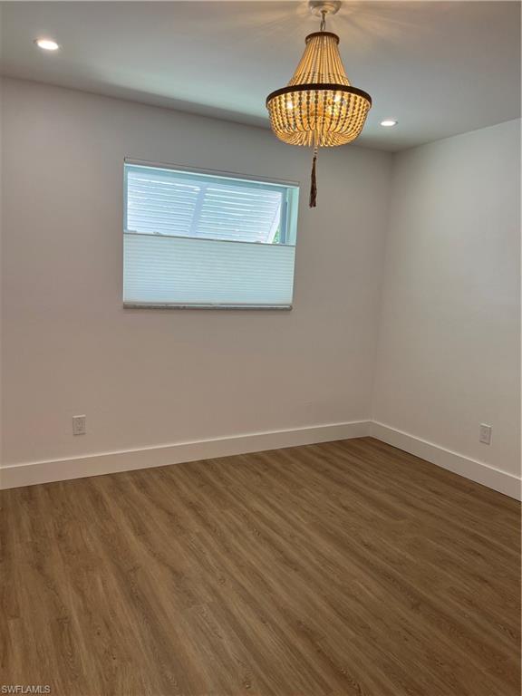 1793 Smugglers Cove, Unit B Naples, FL 34112 - Photo 16 of 23 a view of a room with wooden floor and a chandelier