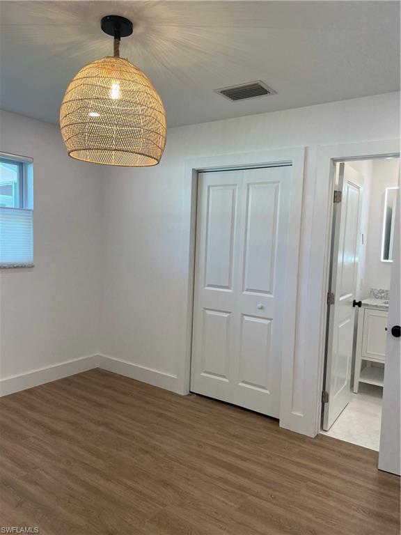 1793 Smugglers Cove, Unit B Naples, FL 34112 - Photo 20 of 23 an empty room with wooden floor cabinet and windows