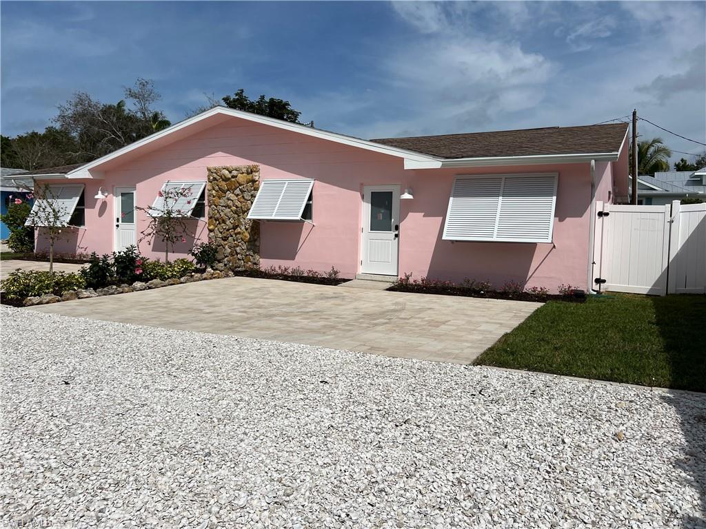 1793 Smugglers Cove, Unit B Naples, FL 34112 - Photo 3 of 23 a front view of a house with a yard