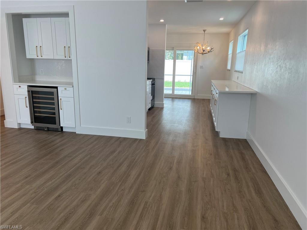 1793 Smugglers Cove, Unit B Naples, FL 34112 - Photo 4 of 23 an empty room with wooden floor and windows