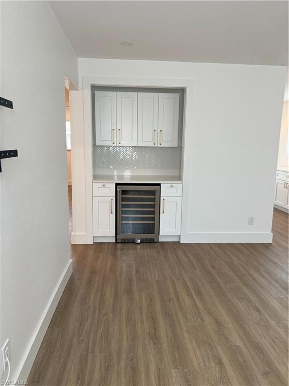 1793 Smugglers Cove, Unit B Naples, FL 34112 - Photo 5 of 23 a view of an empty room with wooden floor and a window
