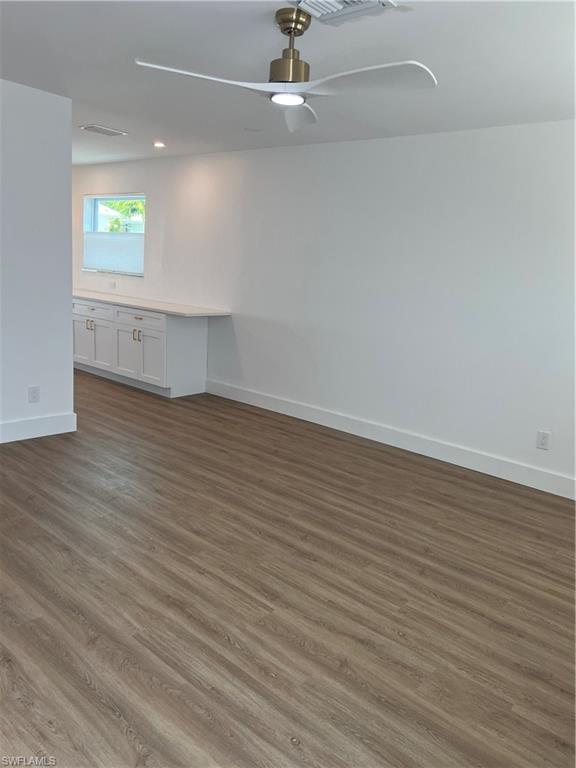 1793 Smugglers Cove, Unit B Naples, FL 34112 - Photo 6 of 23 an empty room with wooden floor and windows