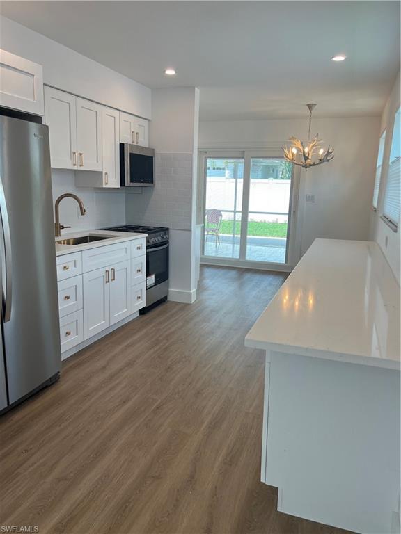 1793 Smugglers Cove, Unit B Naples, FL 34112 - Photo 7 of 23 a kitchen with stainless steel appliances a refrigerator sink and stove