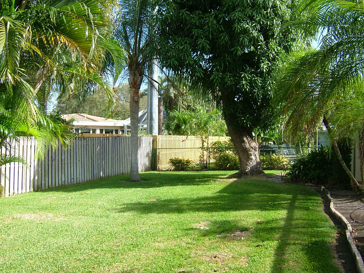773 Apple Tree Lane Boca Raton, FL 33486 - Photo 23 of 25 a view of a backyard with large trees and wooden fence