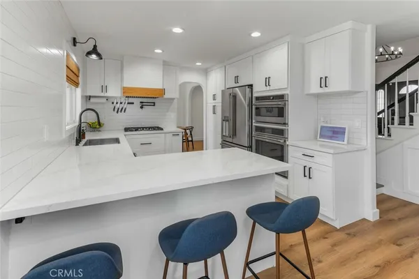 a kitchen with stainless steel appliances a sink and a refrigerator