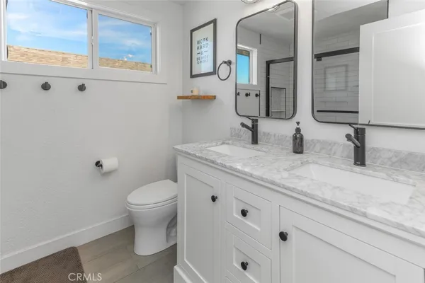 a bathroom with a granite countertop toilet sink and mirror