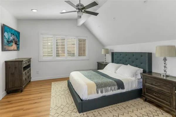 a bedroom with a large bed and a flat tv screen on dresser