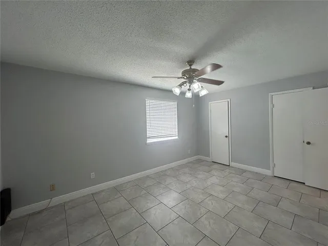 an empty room with closet and a chandelier fan