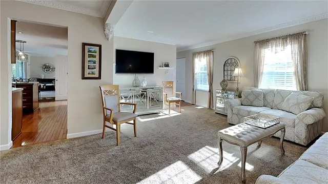 a living room with furniture a flat screen tv and a window