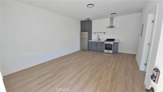 a view of a kitchen with a sink and a refrigerator